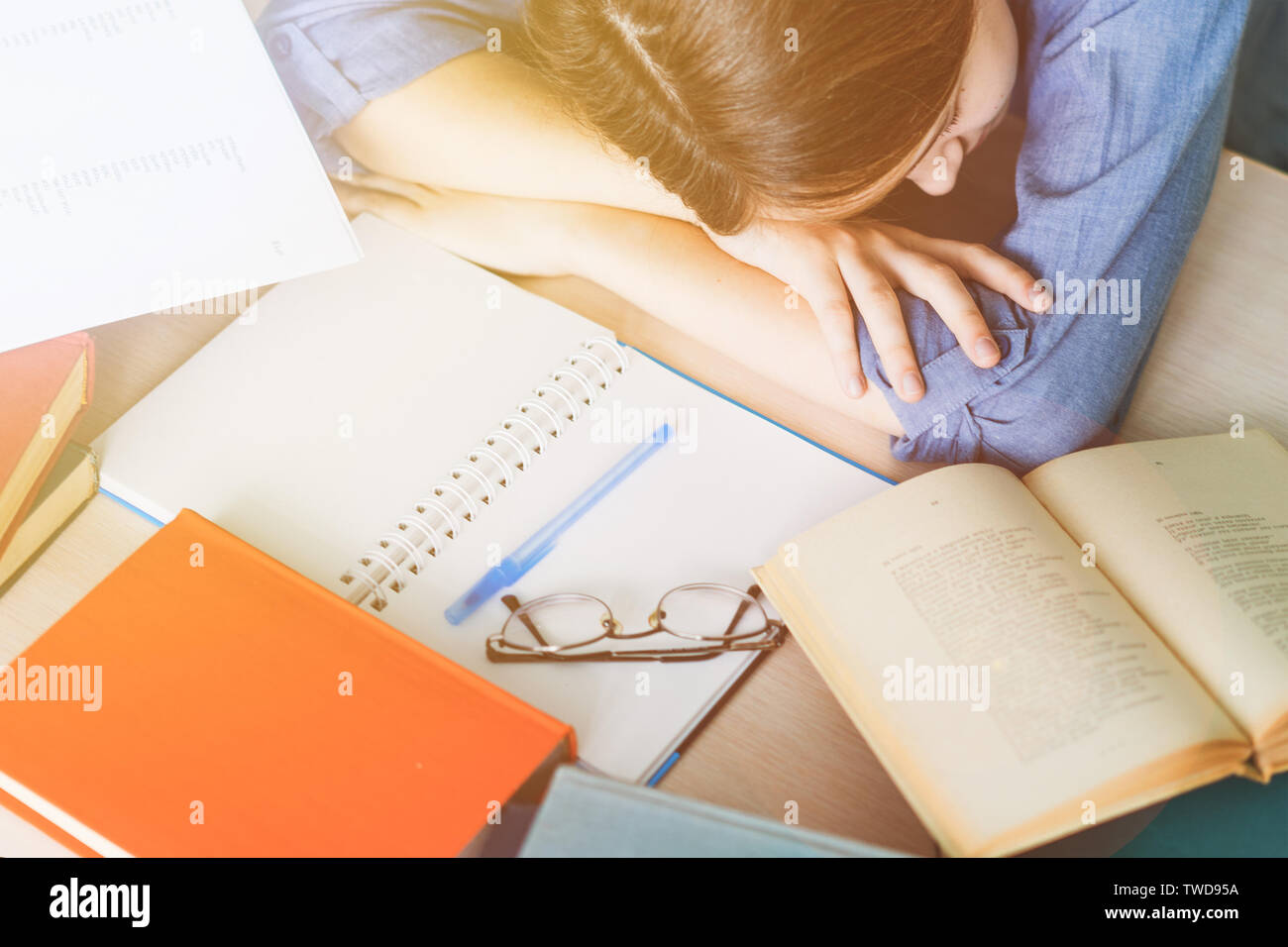 Stressed college student tired of hard learning with books in exams tests preparation