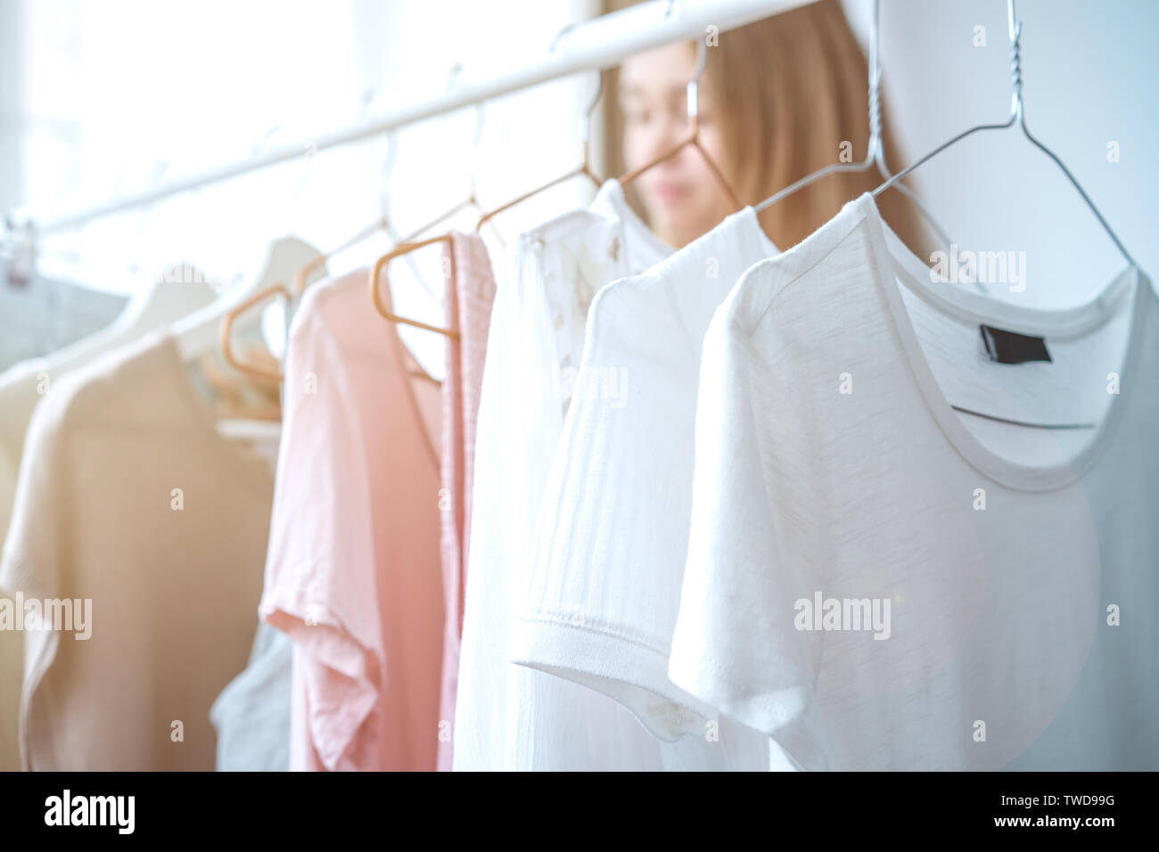 clothing, fashion, style and people concept - woman choosing clothes at home wardrobe Stock Photo