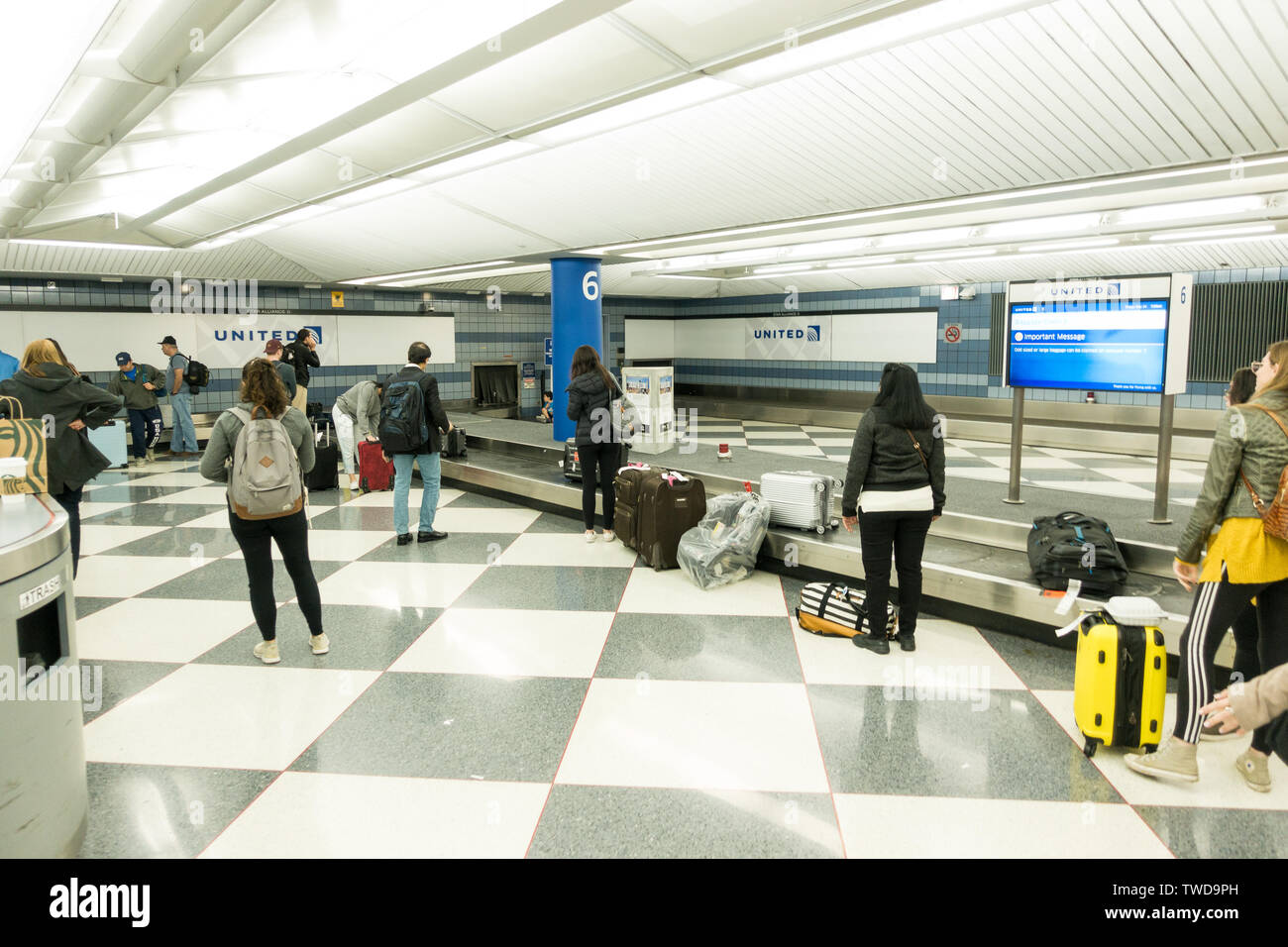 People awaiting at the luggage carousel / conveyor belt at the baggage