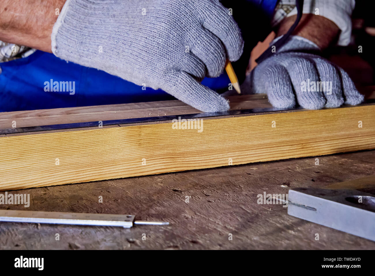 Carpenter works on woodworking machines in the carpentry workshop. A man works with a tree Stock Photo