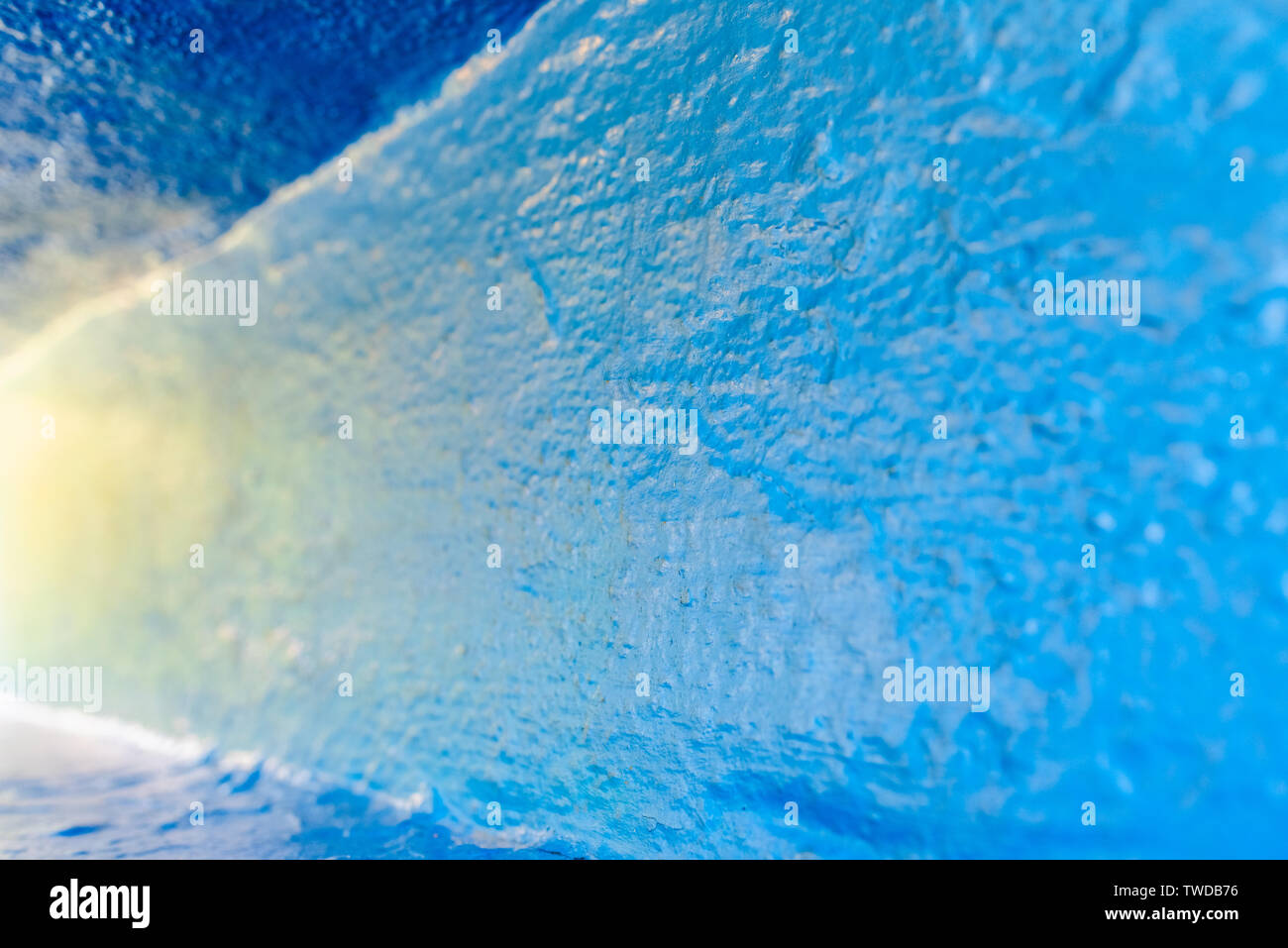 Background with rough texture of a wall painted blue and illuminated at ...