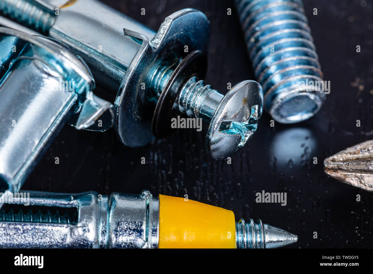 A Macro Image of Drywall Anchors, Screws and Fasteners on a wooden