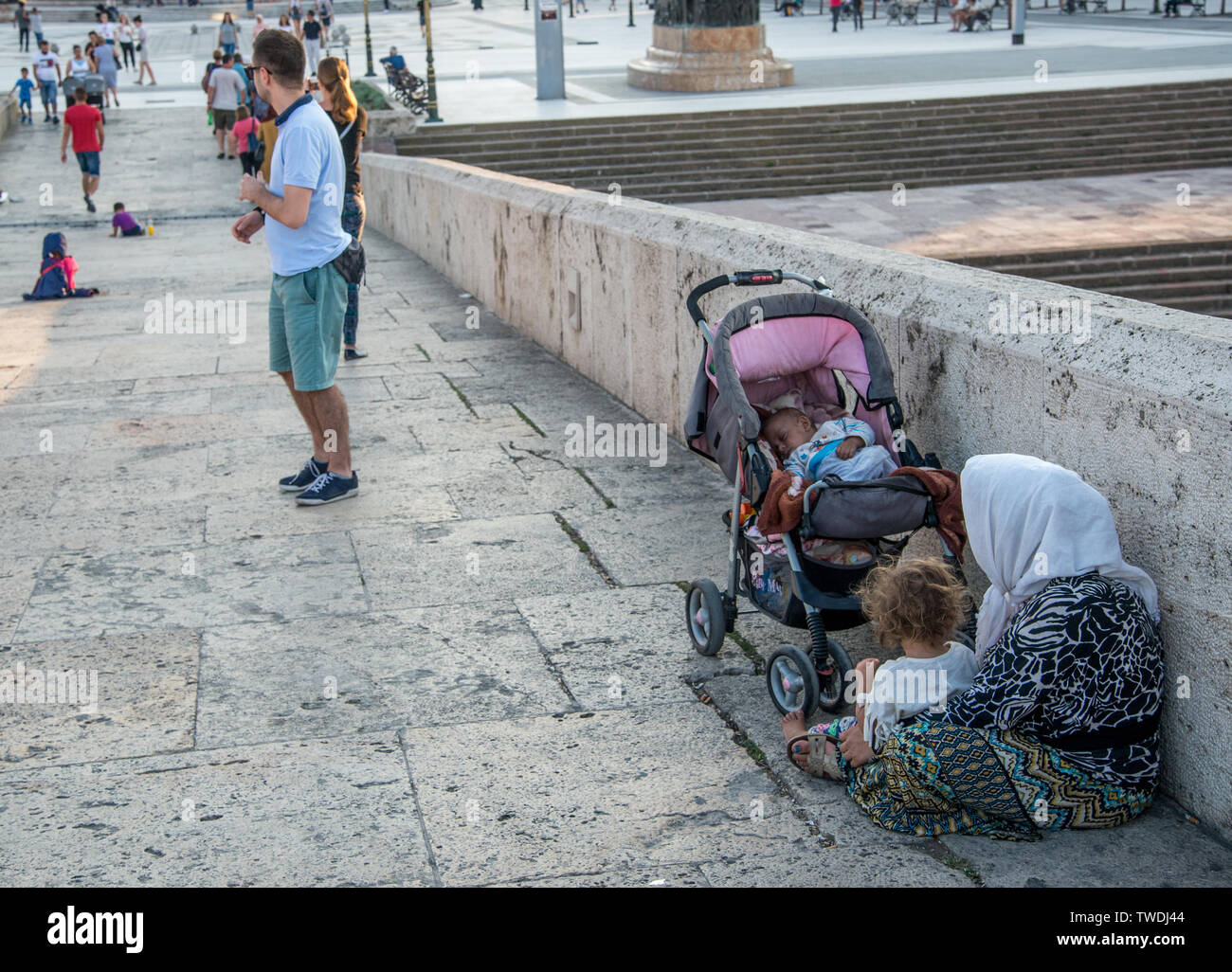 SKOPJE,MACEDONIA-AUGUST 29,2018:Albanian Roma woman and children beg for money,sitting along Stone Bridge,next to Macedonia square,Skopje. Stock Photo