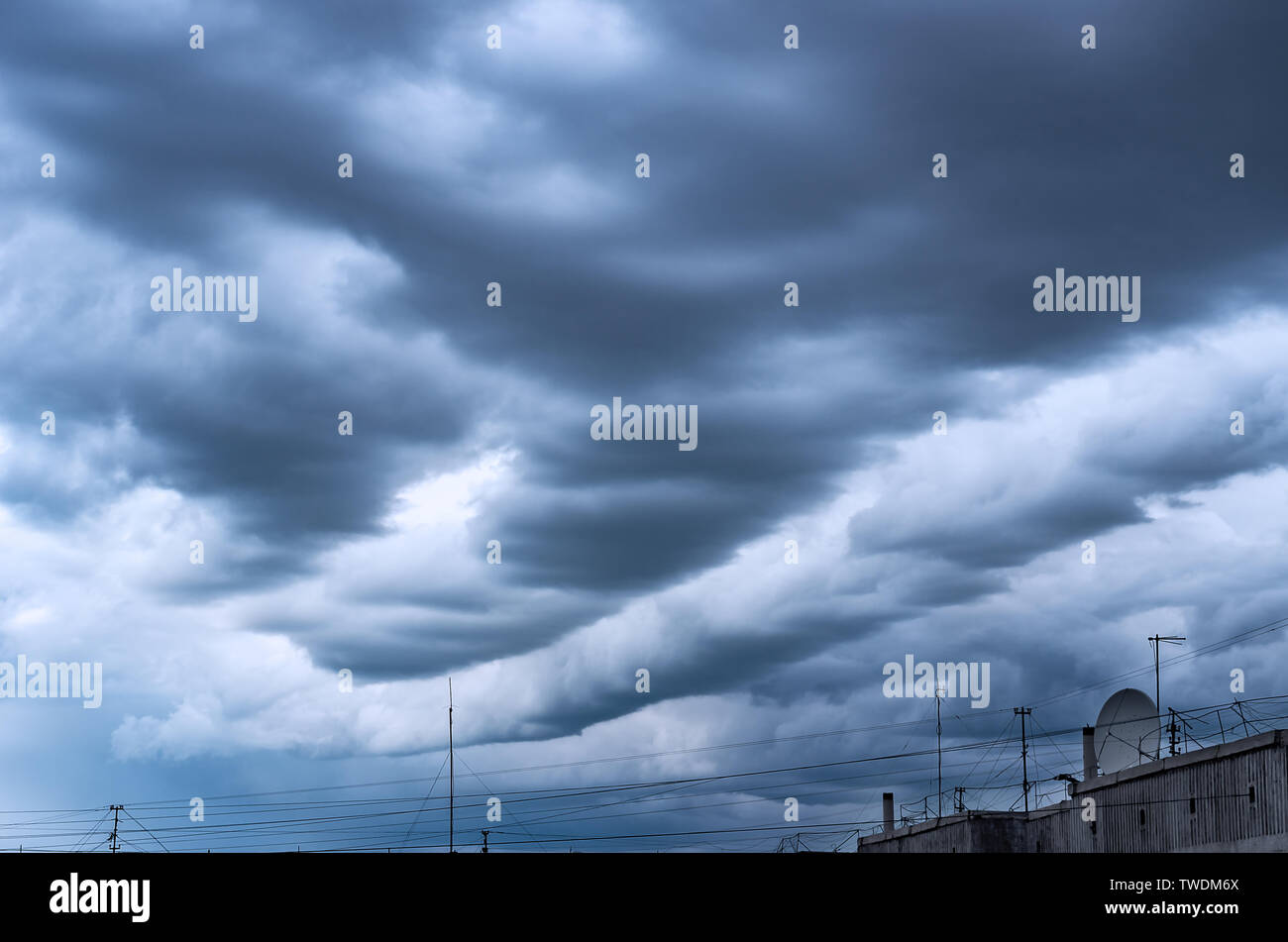 Dramatic Stormy Clouds over the HighRise Rooftop with Cable Wires, TV