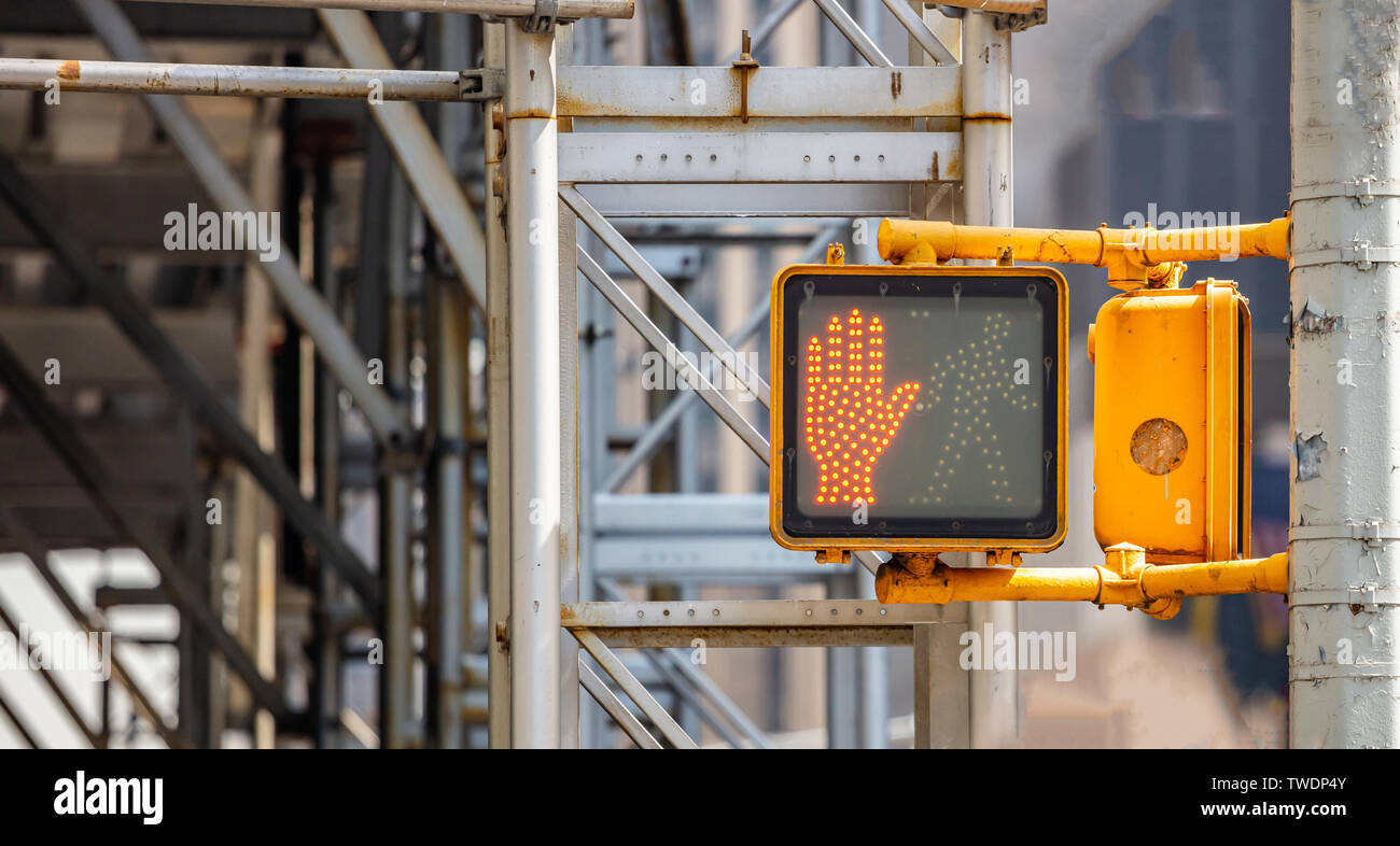 Stop, dont walk red hand traffic signal for pedestrians in New York city center, blur metal structure background, closeup view, copy space Stock Photo
