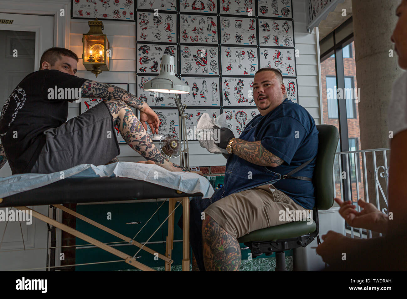 Brooklyn, United States. 19th June, 2019. Tattoo artist Bert Krak, center. Beyond the Streets, the premier exhibition of graffiti, street art and beyond opened in Brooklyn, New York on June 19, 2019. The massive show celebrates more than 150 artists from around the world including Shepard Fairey, Beastie Boys, Glen E. Friedman, SWOON and Guerrilla Girls. Credit: Michael Nigro/Alamy Live News Stock Photo