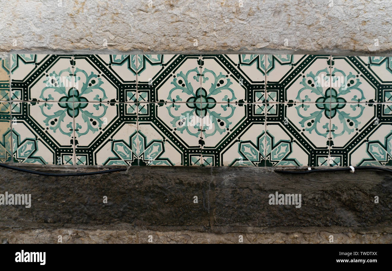 Close up shot of green and white decorative tiles in Lisbon, Portugal. Azulejo is a form of Portuguese and Spanish painted tin-glazed ceramic tiles. Stock Photo