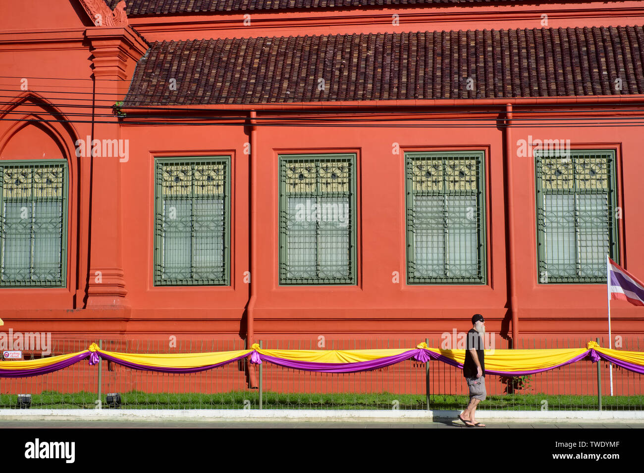 A foreign tourist passes the Thawornwatthu Building or Tuek Daeng, a former library for monksin  Bangkok, Thailand Stock Photo
