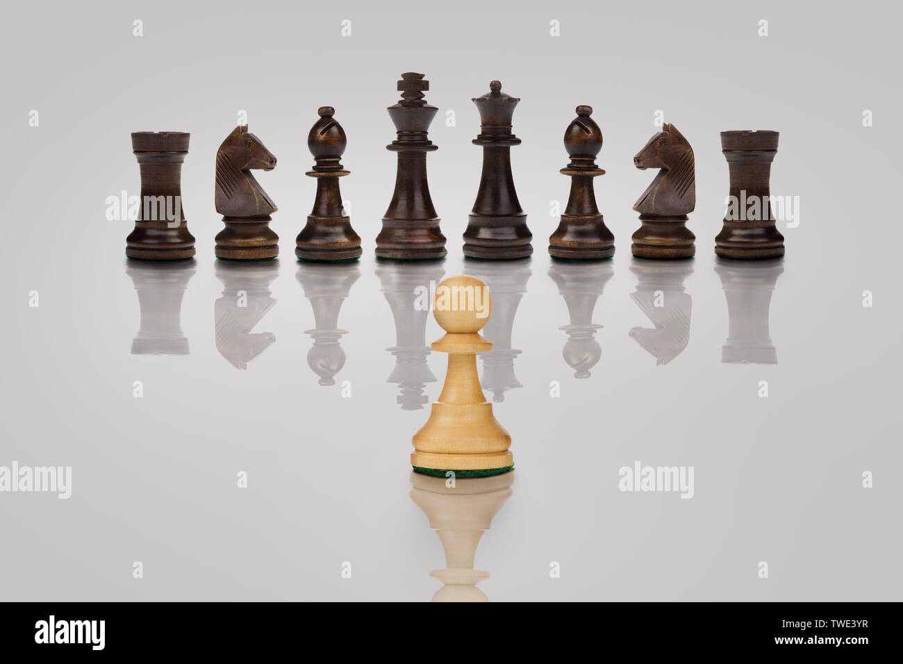 White pawn chess piece facing opposition on chess board Stock Photo