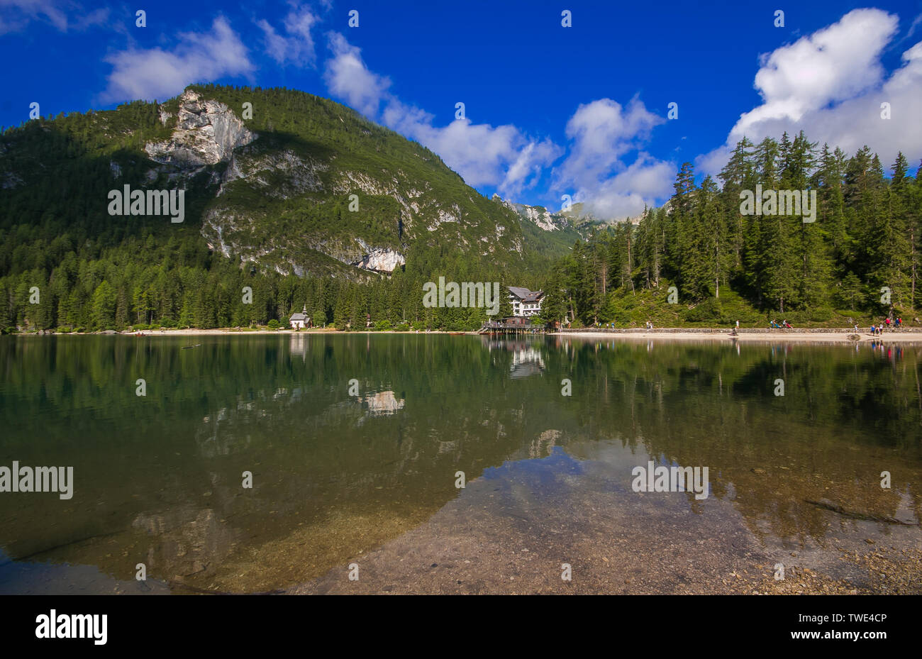 Braies Lake in Dolomites mountains forest trail in background, Sudtirol, Italy. Lake Braies is also known as Lago di Braies. The lake is surrounded by Stock Photo