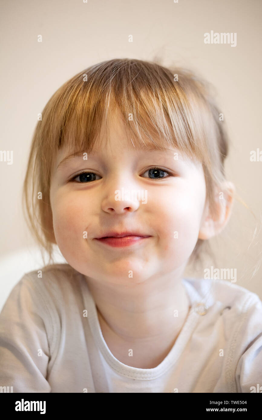 cute smiling child girl with blonde hair and quiff closeup portrait Stock Photo