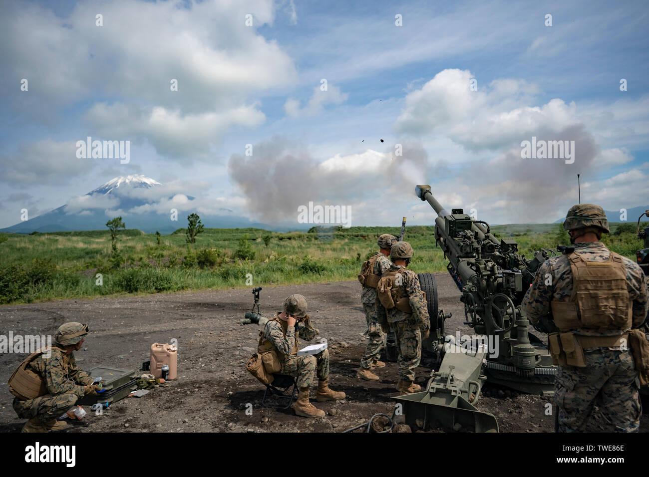 U.S. Marines with India Battery, 3rd Battalion,12th Marine Regiment, fire an M777 Howitzer during Exercise Fuji Viper, at Combined Arms Training Center, Camp Fuji, June 14, 2019. The M777 uses a digital fire-control system to provide navigation, pointing and self-location, allowing it to be put into action quickly. (U.S. Marine Corps photo by Cpl. Esgar Rojas) Stock Photo