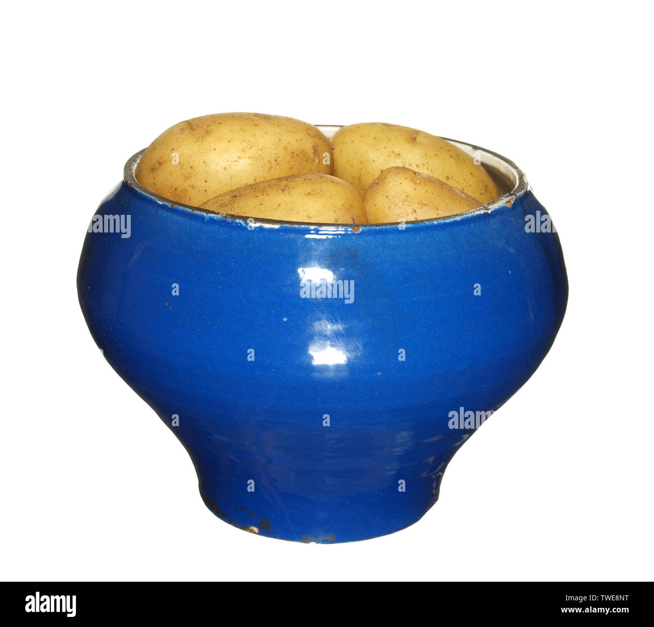 Old vintage iron pot covered with blue enamel filled with potatoes