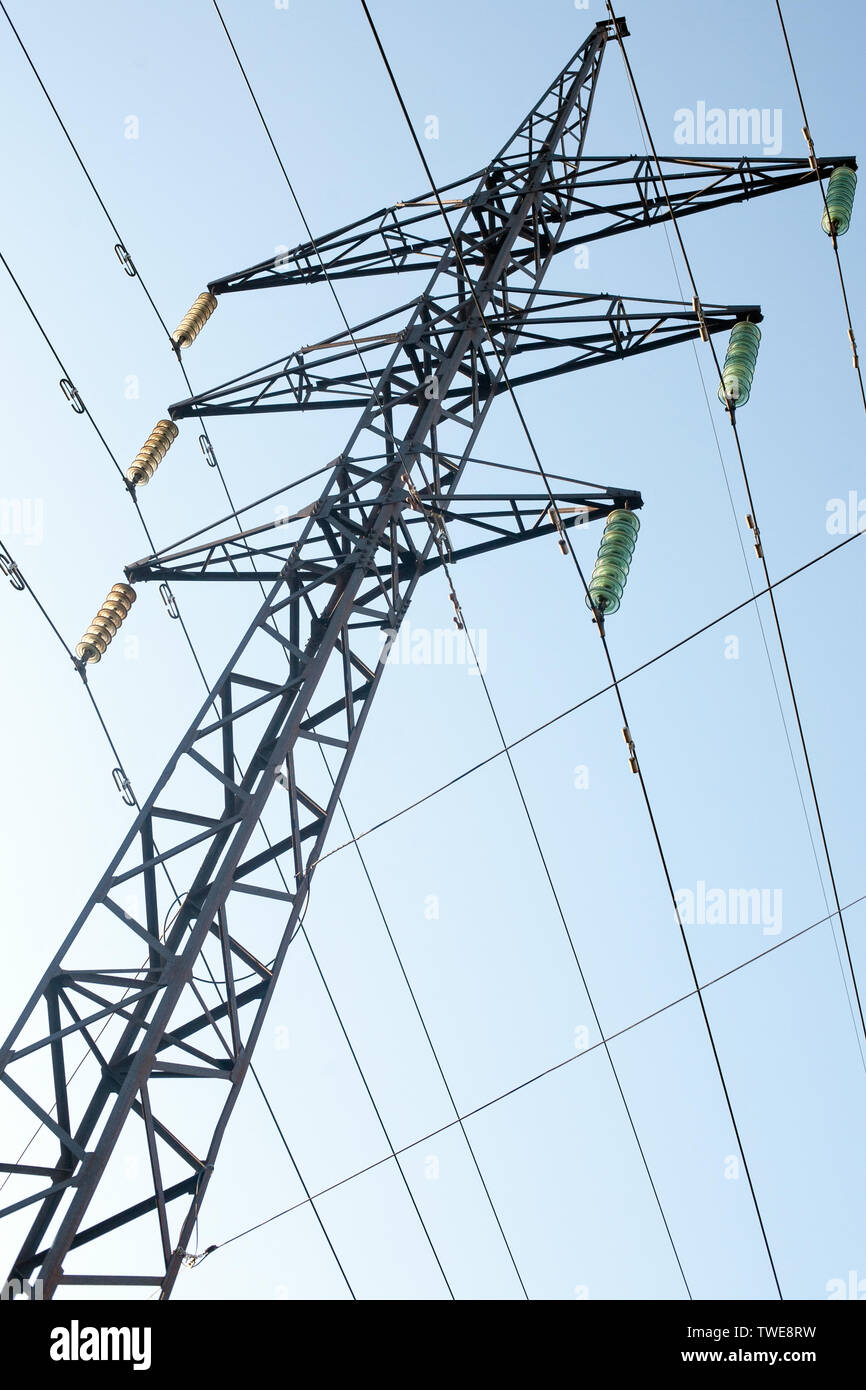 power line pole with cables and wire black silhouette on blue sky background closeup view Stock Photo