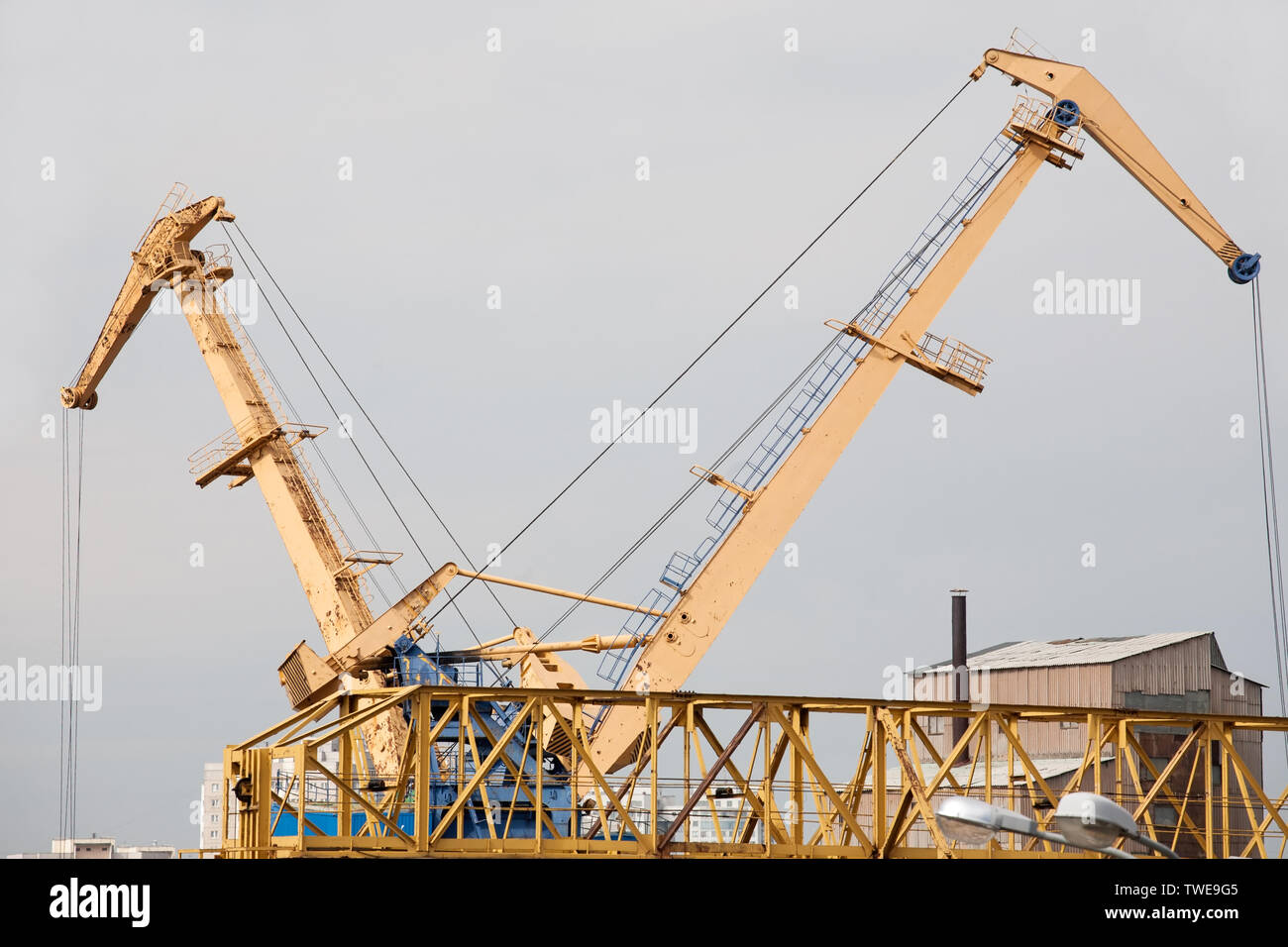 big yellow construction cranes closeup view on outdoor sky background