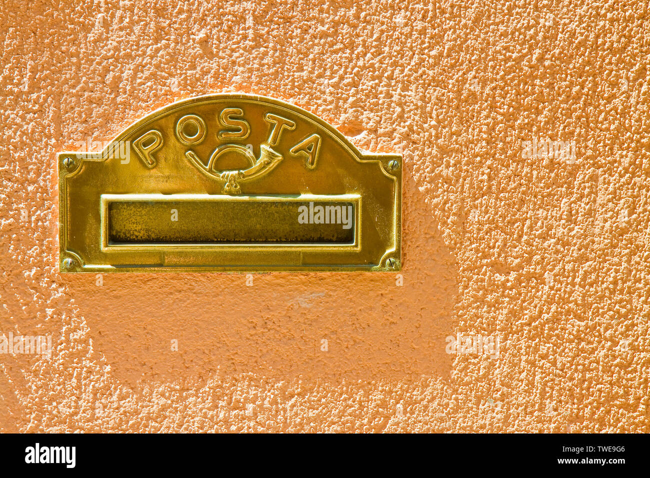 Brass mail box built into a colored plaster wall Stock Photo