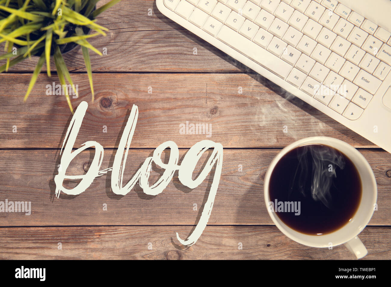 Blog text with computer keyboard, cup of coffee and plant pot. Wooden ...
