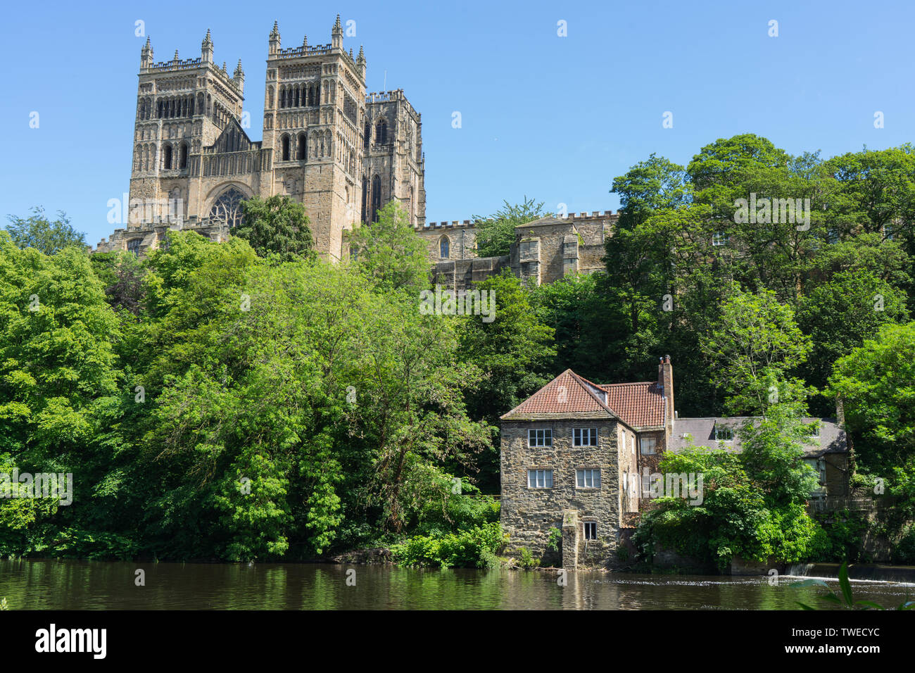 Durham Cathedral above the river wear with fulling mill on the banks of the river with blue skies Stock Photo