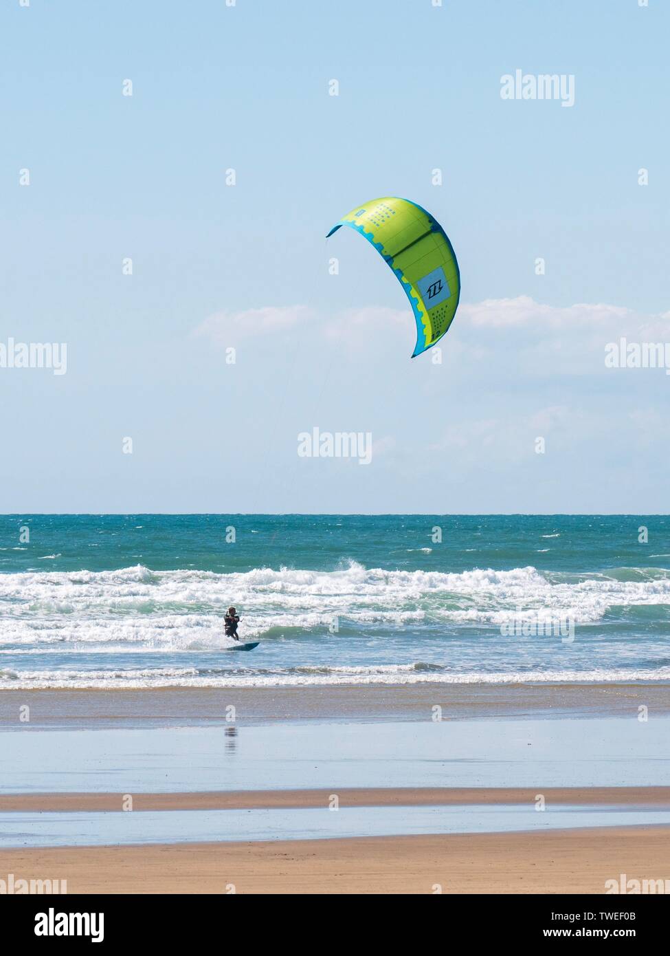 A kiteboarder on the sea at a shallow beach in Devon, UK Stock Photo