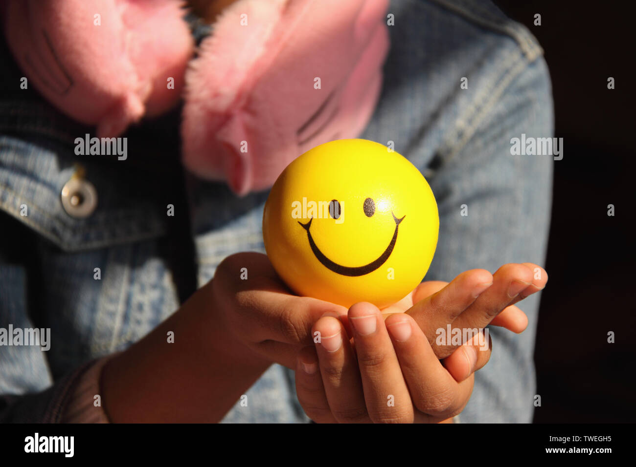 Girl holding a ball with smiley face Stock Photo