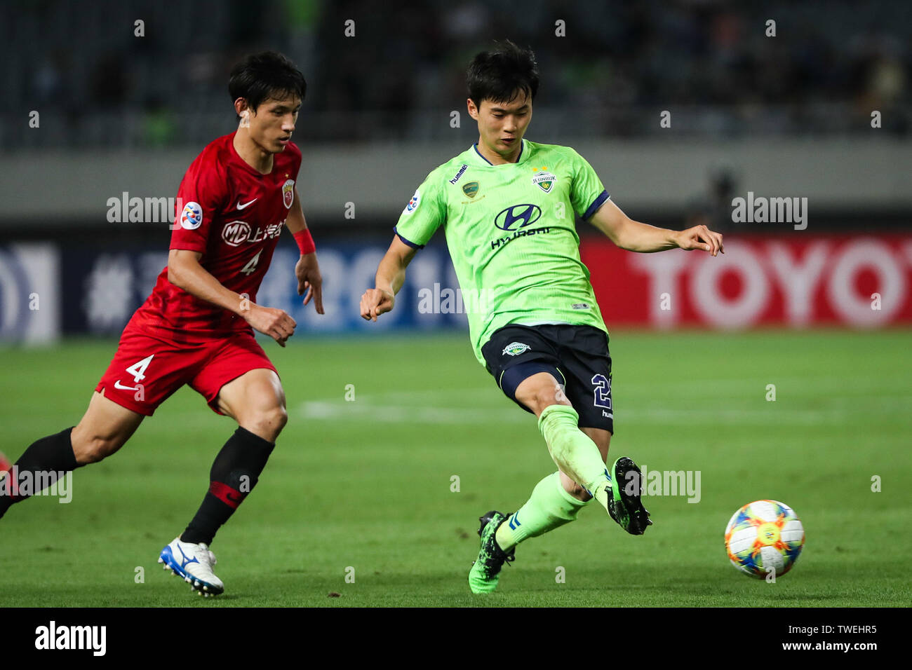 Kim Jin-su, right, of South Korea's Jeonbuk Hyundai Motors FC passes the ball against Wang Shenchao of Shanghai SIPG in the eighth-final match during the 2019 AFC Champions League in Shanghai, China, 19 June 2019. Two-time champions Jeonbuk Hyundai Motors will take an advantage into the second leg of their 2019 AFC Champions League (ACL) Round of 16 game with Shanghai SIPG FC next week after netting an away goal in their 1-1 draw in Shanghai on Wednesday. Stock Photo