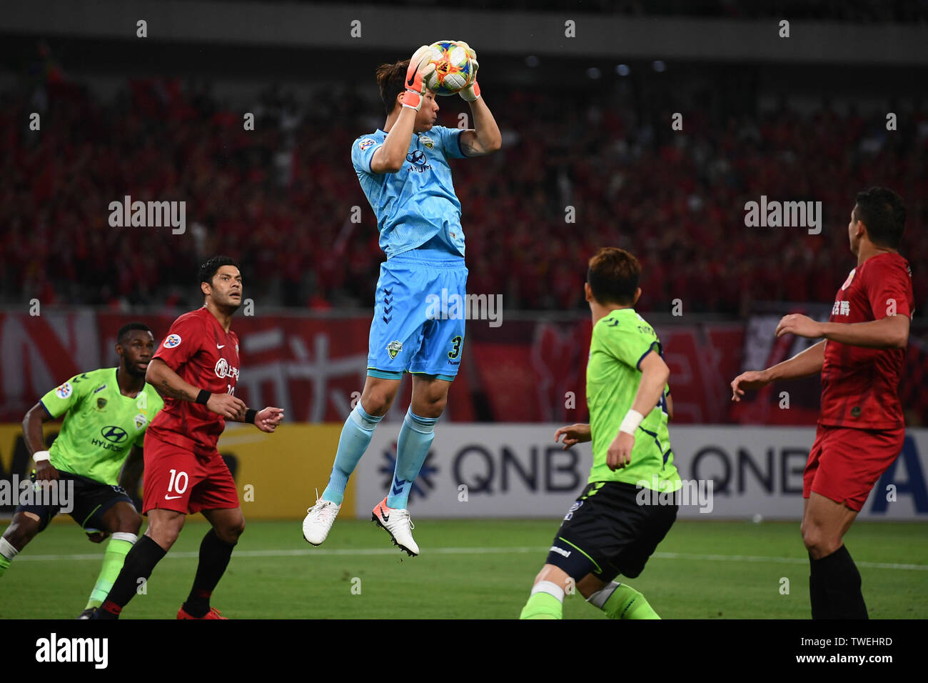 Song Bum-keun, top, of South Korea's Jeonbuk Hyundai Motors FC passes the  ball against players of Shanghai SIPG in the eighth-final match during the  2019 AFC Champions League in Shanghai, China, 19