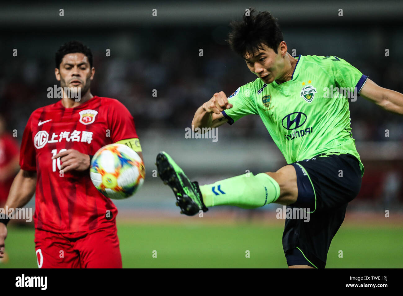 Kim Jin-su, right, of South Korea's Jeonbuk Hyundai Motors FC passes the ball against Brazilian football player Givanildo Vieira de Sousa, known as Hulk, of Shanghai SIPG in the eighth-final match during the 2019 AFC Champions League in Shanghai, China, 19 June 2019. Two-time champions Jeonbuk Hyundai Motors will take an advantage into the second leg of their 2019 AFC Champions League (ACL) Round of 16 game with Shanghai SIPG FC next week after netting an away goal in their 1-1 draw in Shanghai on Wednesday. Stock Photo