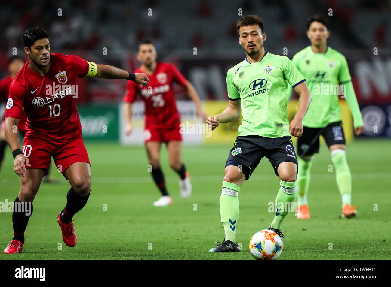 Brazilian football player Givanildo Vieira de Sousa, known as Hulk, left, of China's Shanghai SIPG F.C. passes the ball against Shin Hyung-min of South Korea's Jeonbuk Hyundai Motors FC in the eighth-final match during the 2019 AFC Champions League in Shanghai, China, 19 June 2019. Two-time champions Jeonbuk Hyundai Motors will take an advantage into the second leg of their 2019 AFC Champions League (ACL) Round of 16 game with Shanghai SIPG FC next week after netting an away goal in their 1-1 draw in Shanghai on Wednesday. Stock Photo