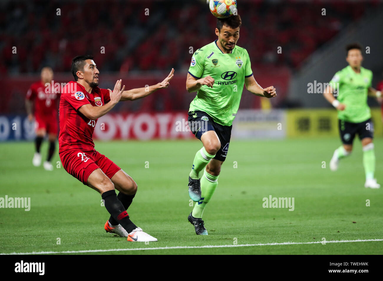 Shin Hyung-min, right, of South Korea's Jeonbuk Hyundai Motors FC heads the ball against Uzbek football player Odil Ahmedov of Shanghai SIPG in the eighth-final match during the 2019 AFC Champions League in Shanghai, China, 19 June 2019. Two-time champions Jeonbuk Hyundai Motors will take an advantage into the second leg of their 2019 AFC Champions League (ACL) Round of 16 game with Shanghai SIPG FC next week after netting an away goal in their 1-1 draw in Shanghai on Wednesday. Stock Photo
