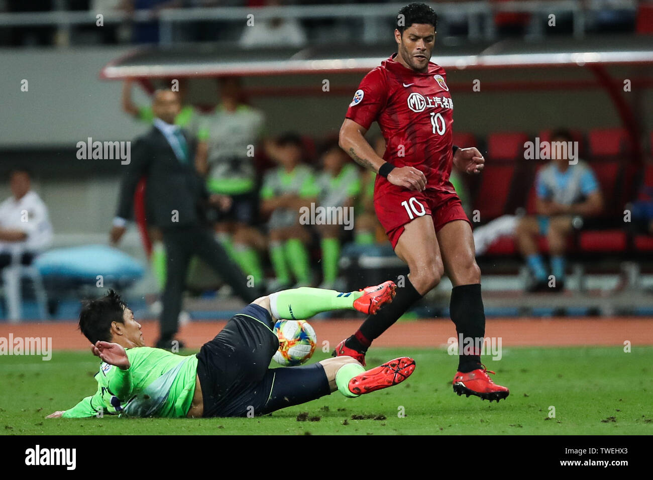 Brazilian football player Givanildo Vieira de Sousa, known as Hulk, right, of China's Shanghai SIPG F.C. passes the ball against a player of South Korea's Jeonbuk Hyundai Motors FC in the eighth-final match during the 2019 AFC Champions League in Shanghai, China, 19 June 2019. Two-time champions Jeonbuk Hyundai Motors will take an advantage into the second leg of their 2019 AFC Champions League (ACL) Round of 16 game with Shanghai SIPG FC next week after netting an away goal in their 1-1 draw in Shanghai on Wednesday. Stock Photo