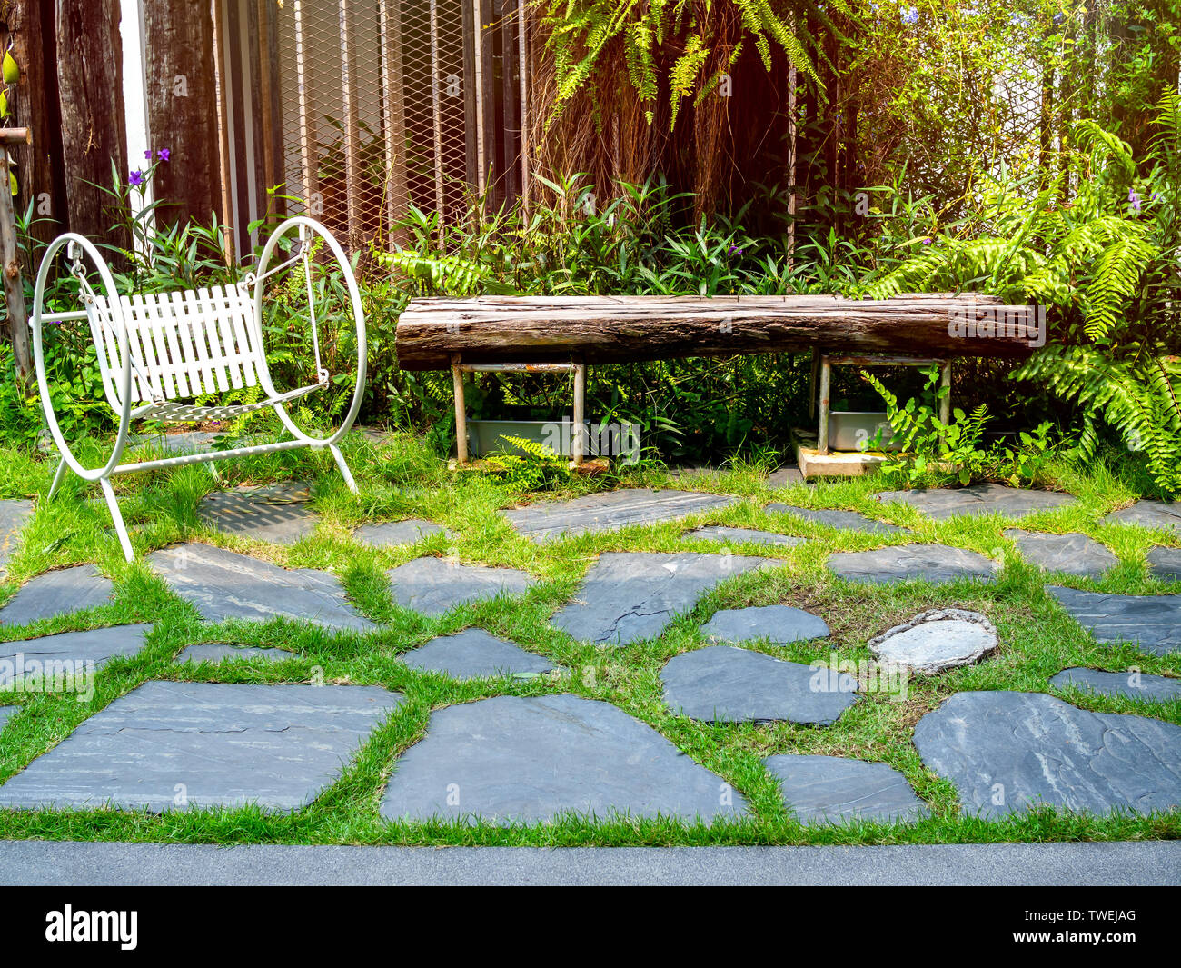 White Vintage Garden Swing Seat On Stone Floor In The Green Garden