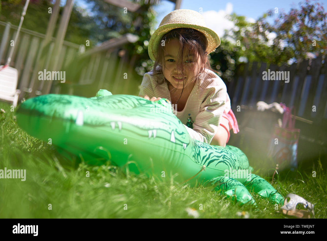 Cute young Asian girl wearing a straw hat playing with an inflatable ...