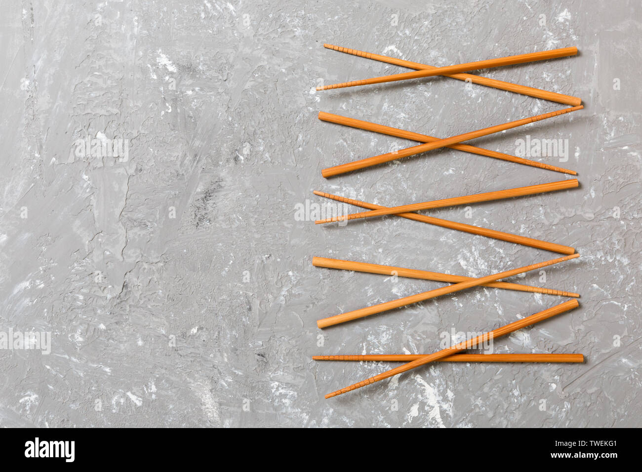 Many bamboo chopsticks on black cement stone background, top view with copy space. a lot of sushi sticks in the form of an ornament. Stock Photo