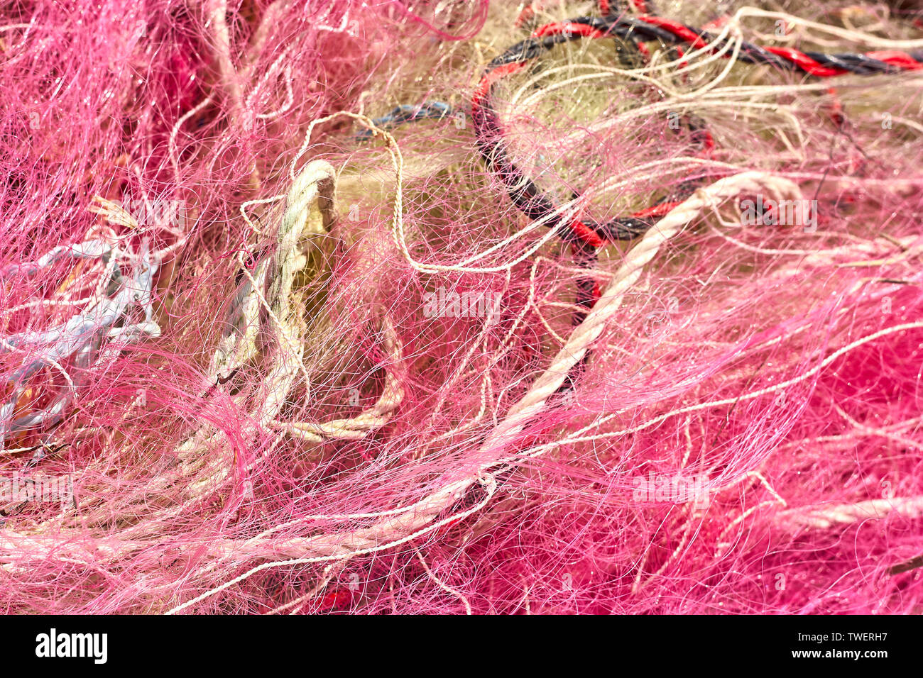 A tangled mess of fishing nets plastic rope and other debris washed up on a coastal beach. Save the Planet stock picture. Stock Photo