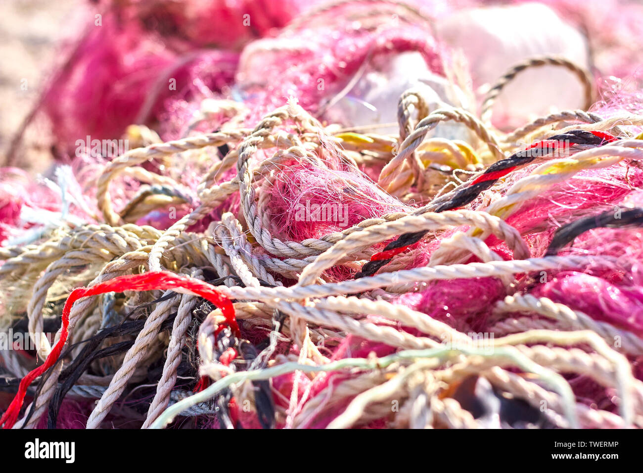 A tangled mess of fishing nets plastic rope and other debris washed up on a coastal beach. Save the Planet stock picture. Stock Photo