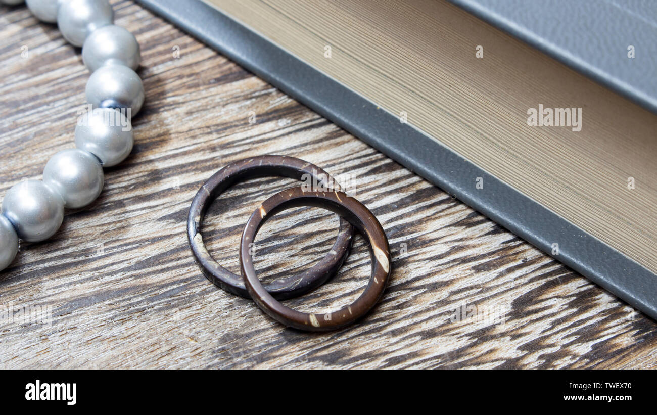 Unique handmade coconut rings in wooden background with props. Artisan wedding ring bands. Love and union concept. Stock Photo