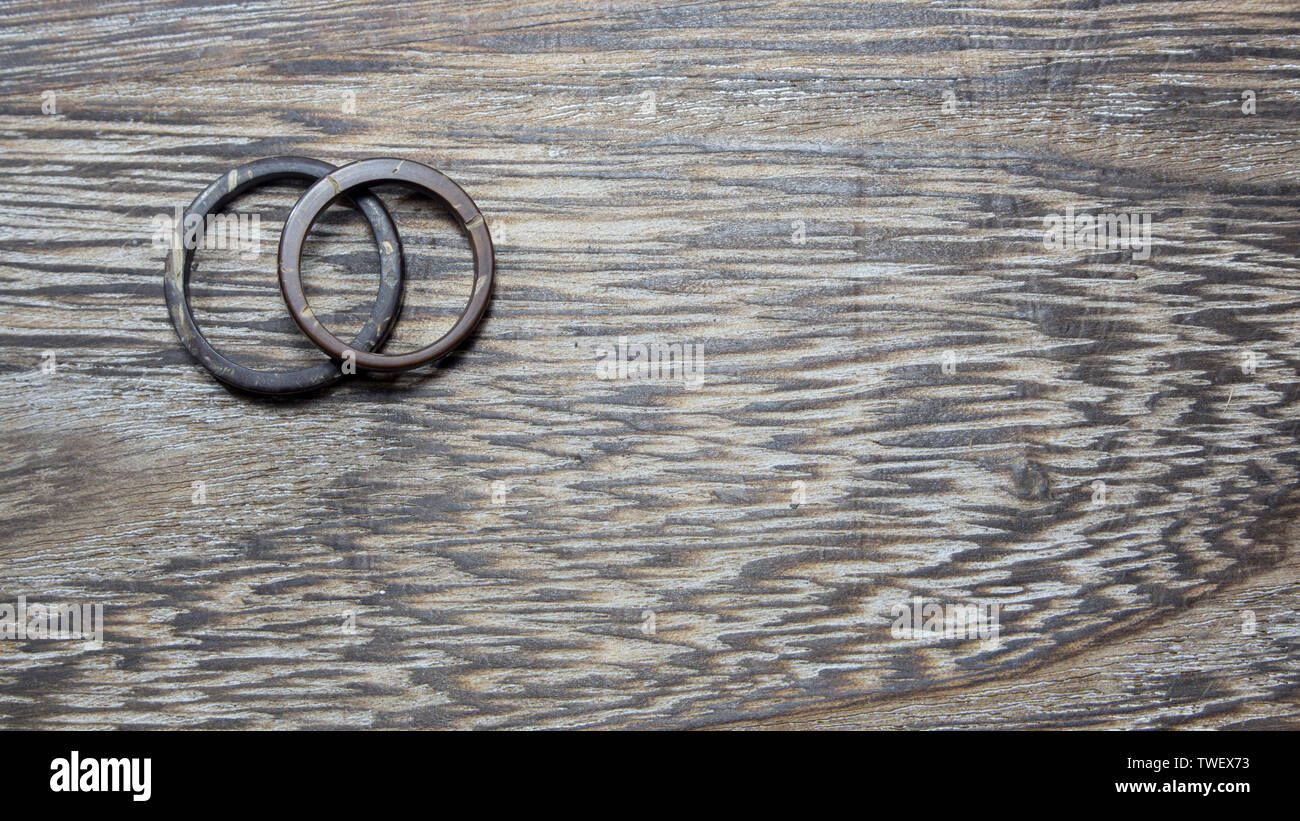 Plain handmade coconut rings in wooden background. Artisan wedding ring bands. Love and union concept. With copy space. Stock Photo