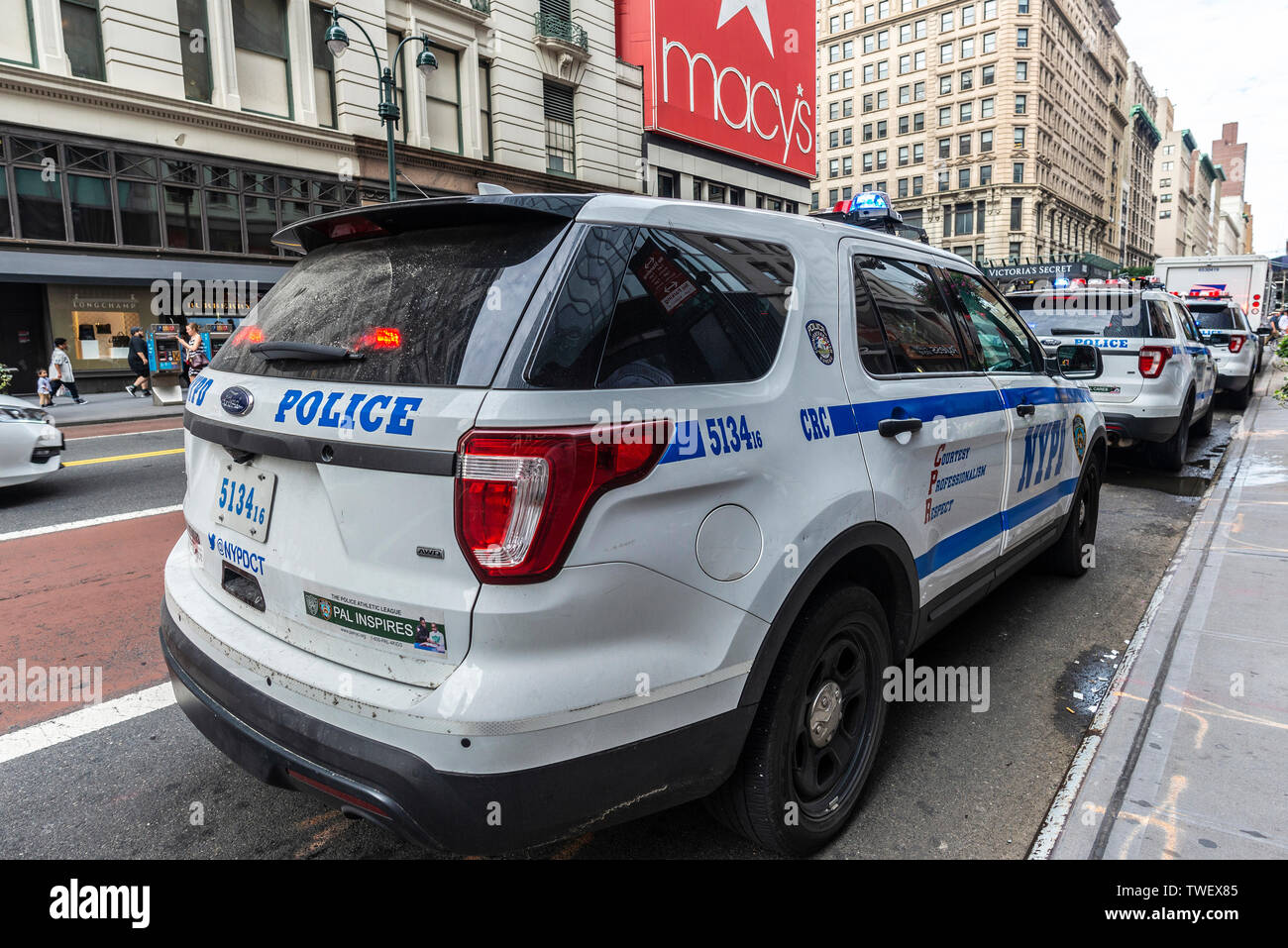 New York City, USA - July 31, 2018: Police car parked on a street in front of Macys department store with people around in Manhattan, New York City, U Stock Photo