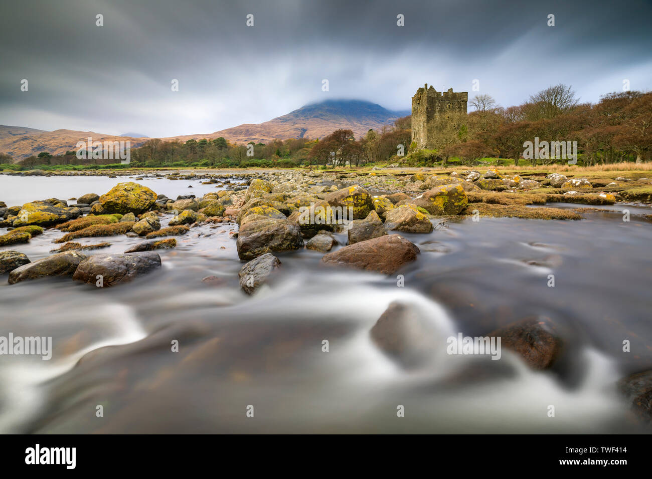 A stream at Loch Buie with Moy Castle in the distance. Stock Photo