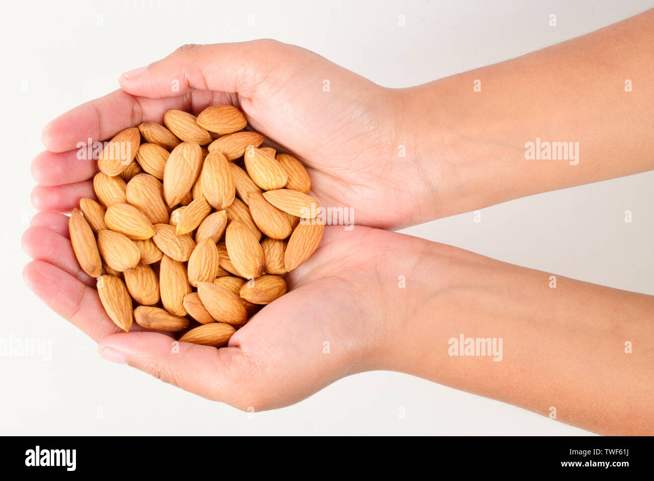 almonds in hand isolated on white background, badam in hand Stock Photo