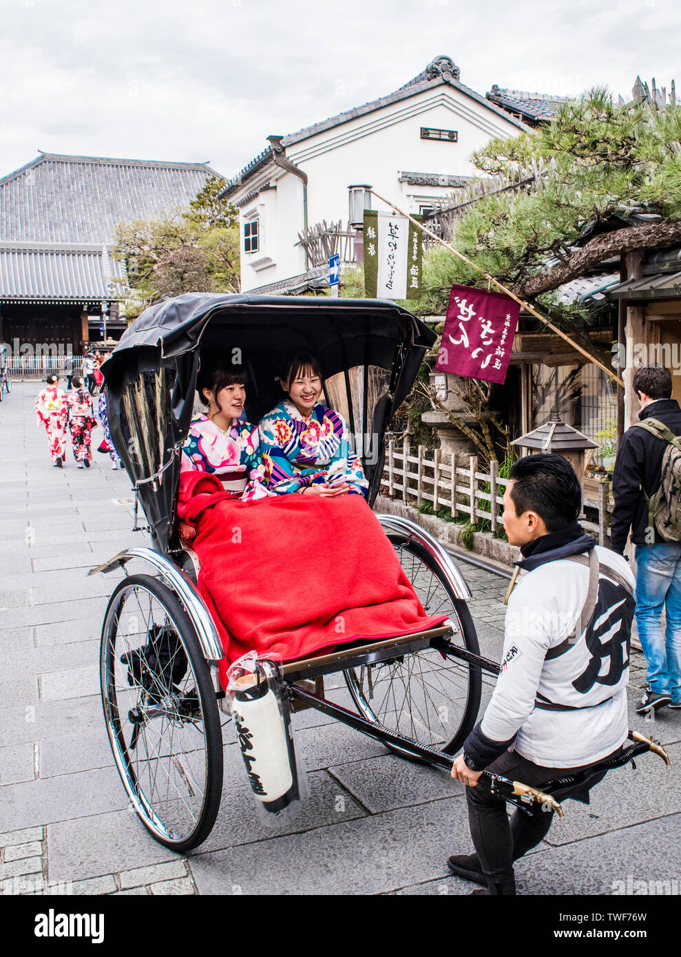 Two women in traditional dress taking rickshaw ride at Kiyomizu-dera Temple in Kyoto in Japan. Stock Photo