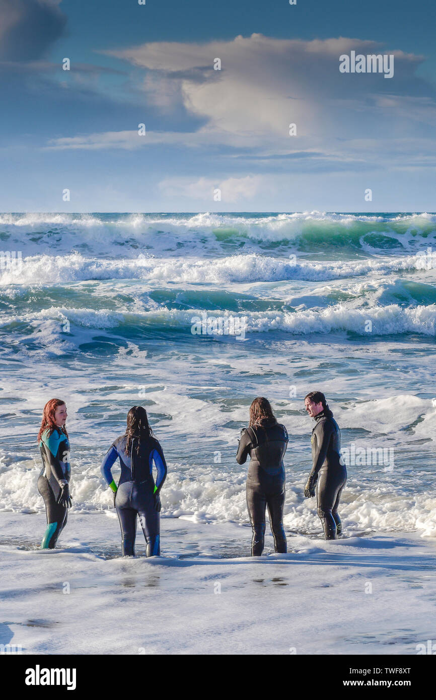 People in wetsuits standing in the sea at Fistral Beach in Newquay in Cornwall Stock Photo Alamy