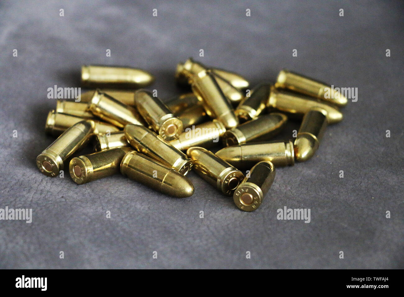 Close up of 9 mm golden pistol bullets ammo on background. Special force units. Stock Photo