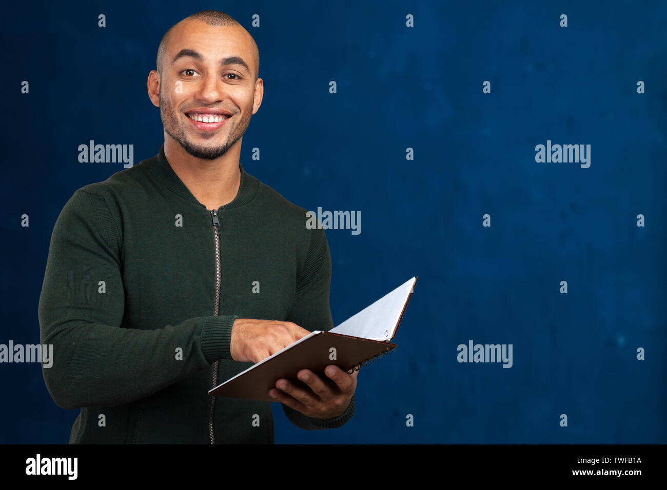 Portrait of happy student while reading book Stock Photo - Alamy
