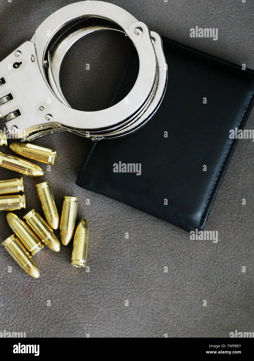 Handcuffs, pistol bullets and ID holder for cops, special forces and defense units equipment. Close up background. Stock Photo