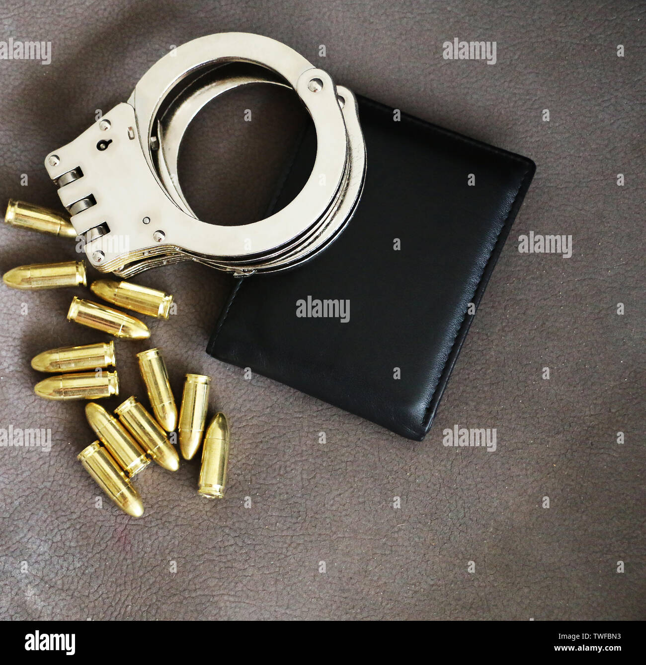 Handcuffs, pistol bullets and ID holder for cops, special forces and defense units equipment. Close up background. Stock Photo