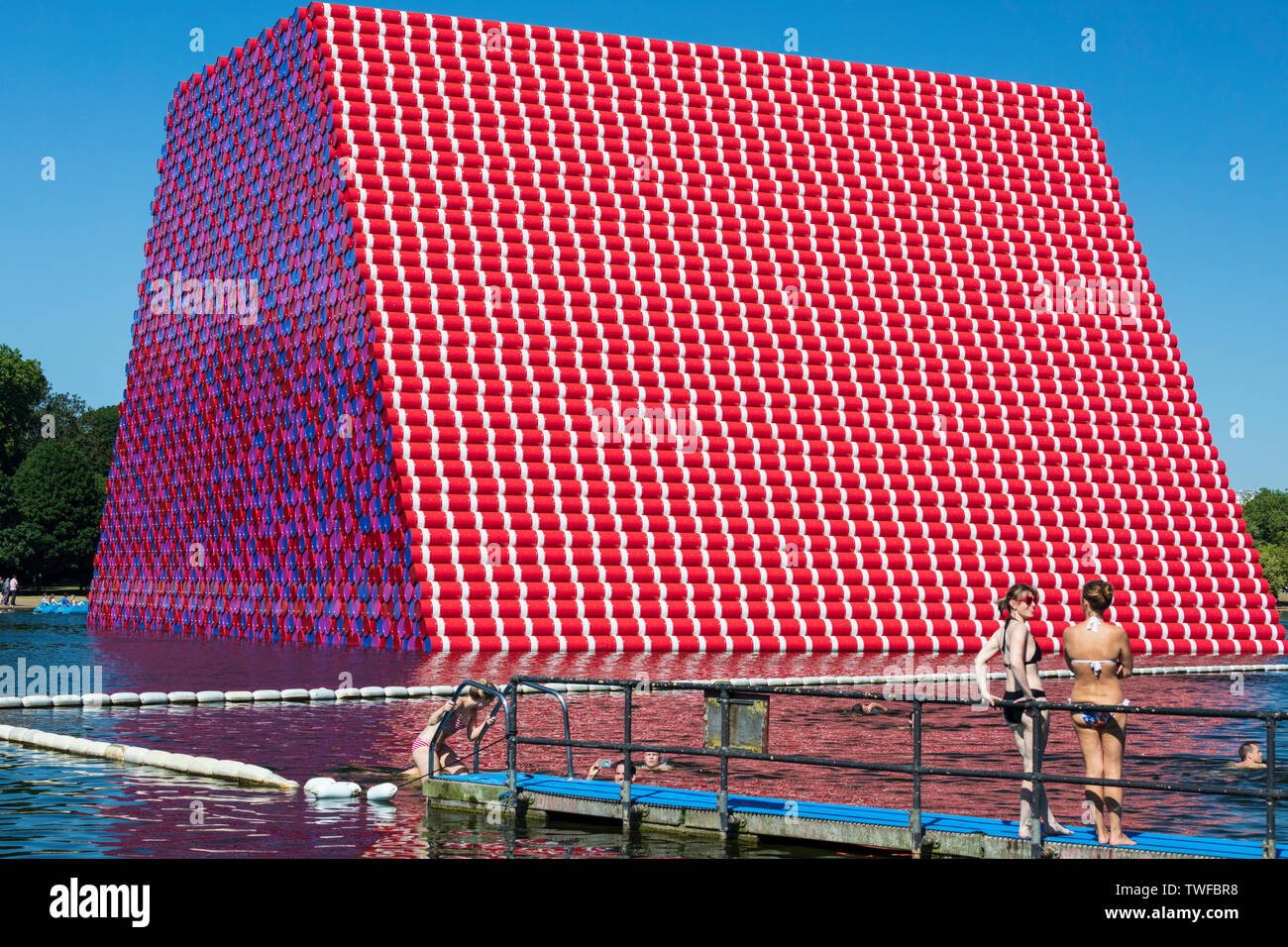 Outdoor swimming at the Serpentine Lake in Hyde Park with The London Mastaba art installation by Christo and Jeanne-Claude in the background. Stock Photo