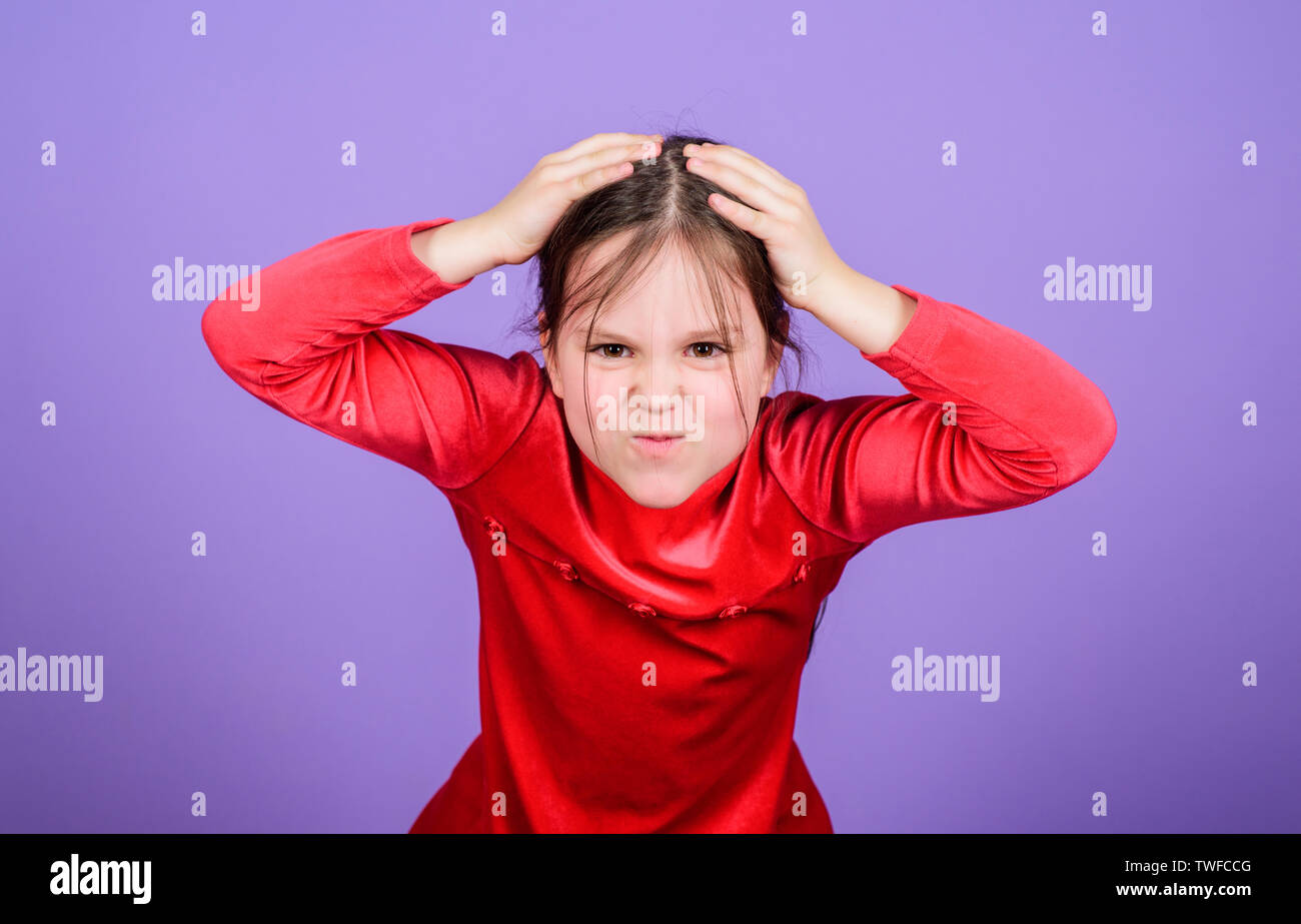 Emotional face small girl violet background. Can not stop her feelings ...