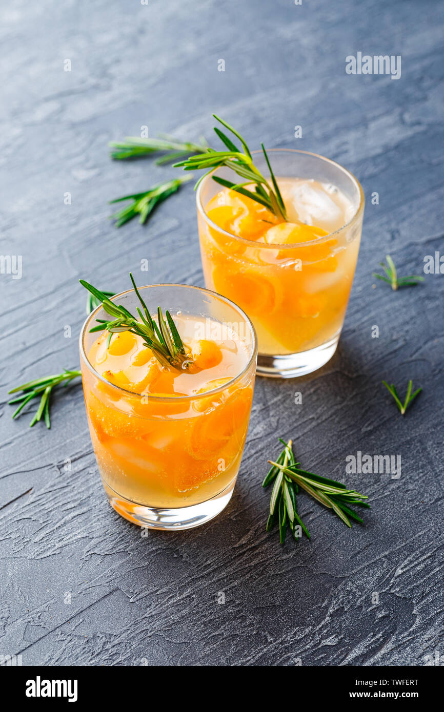 Summer drinks, rosemary aprcot cocktails with ice in glasses. Refreshing summer homemade Alcoholic or non-alcoholic cocktailsor Detox infused flavored Stock Photo
