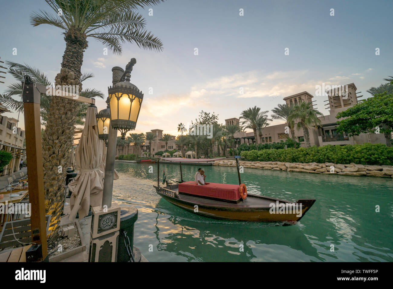 An abra chugs glides along the beautiful waters of Souk Madinat in Dubai. Stock Photo
